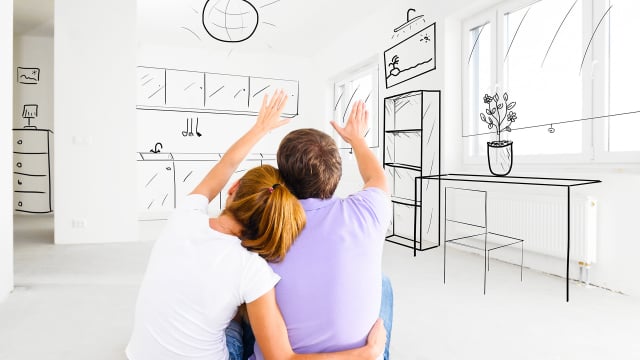 Modern couple viewing a sketched interior design in a bright, minimalist home, emphasizing custom home building and interior design services from Jess Garrison Homes.
