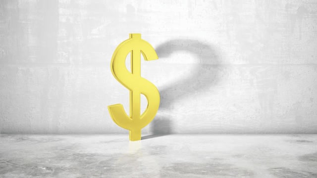 $ dollar sign standing on a concrete surface with a textured gray background, symbolizing real estate investment and home affordability.